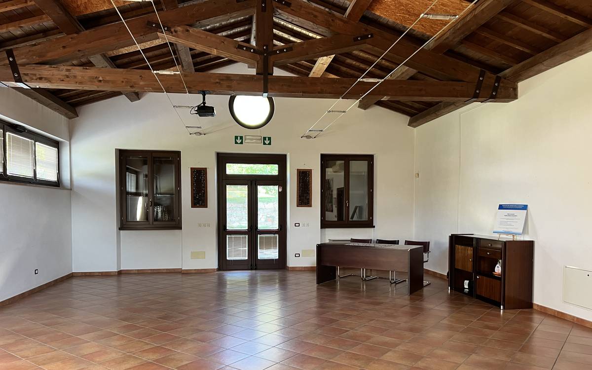 Sala Incontro del Centro della Memoria Comboniana a Verona, spazio luminoso con travi in legno